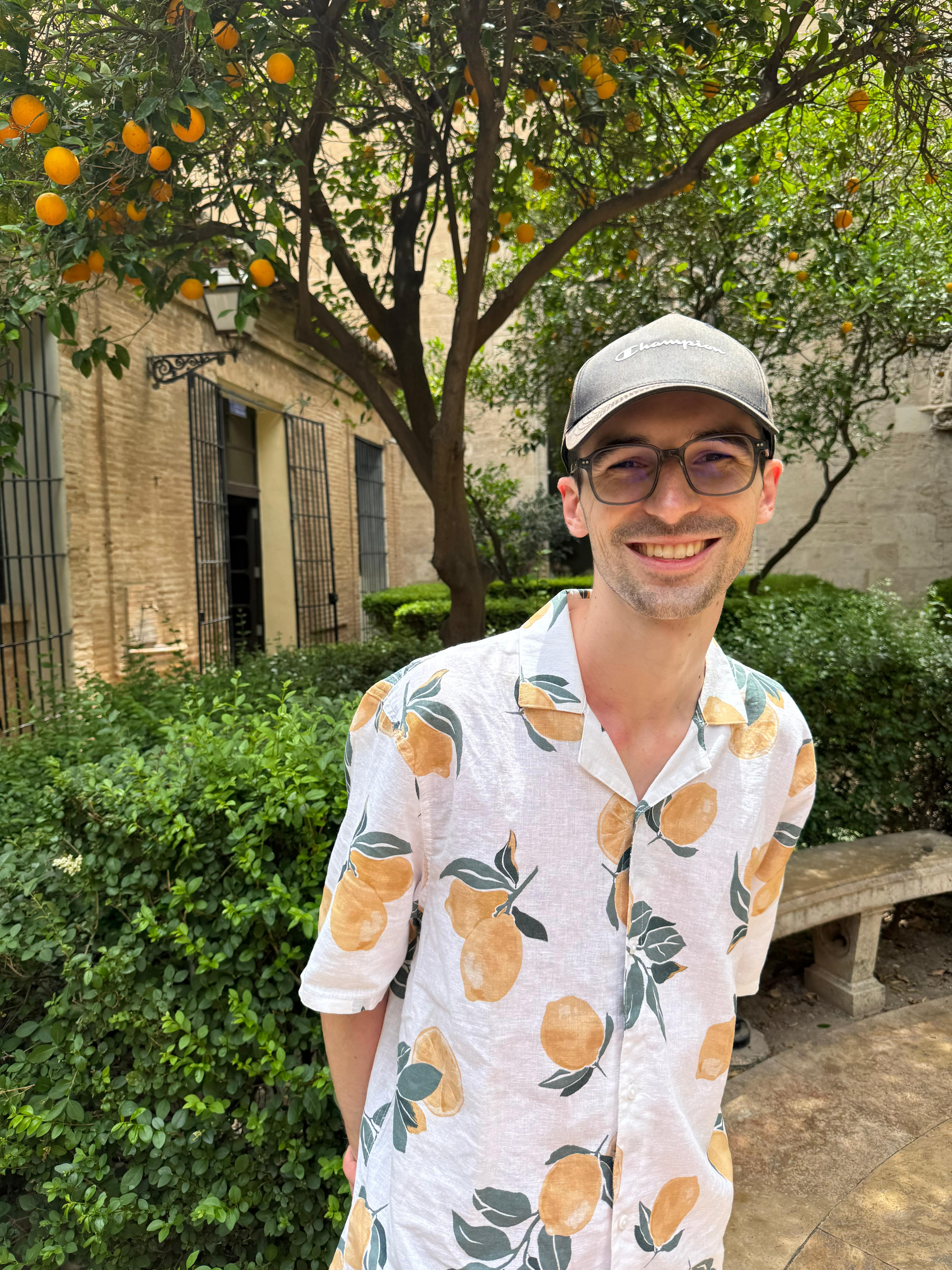 Nick Kramer smiling in a white shirt with lemons in front of a lemon tree